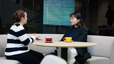 image of two students sat at a round table facing one another