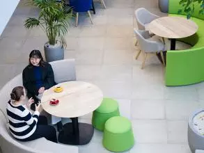 overhead view of two female students sat at a circular table talking